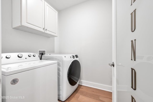 116 W Ave Unit 309, Saratoga Springs, NY 12866 - laundry room featuring cabinet space, washing machine and dryer, light wood-style flooring, and baseboards