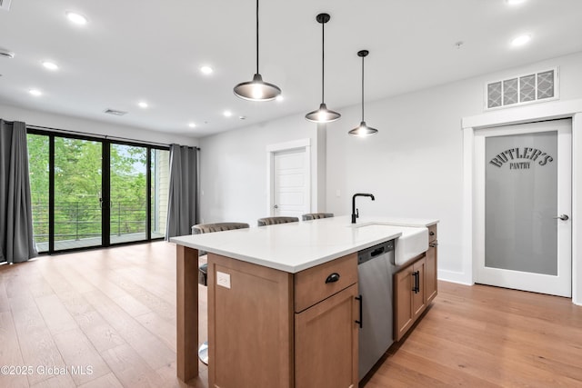 116 W Ave Unit 309, Saratoga Springs, NY 12866 - kitchen with stainless steel dishwasher, light wood-style floors, a breakfast bar, a sink, and recessed lighting