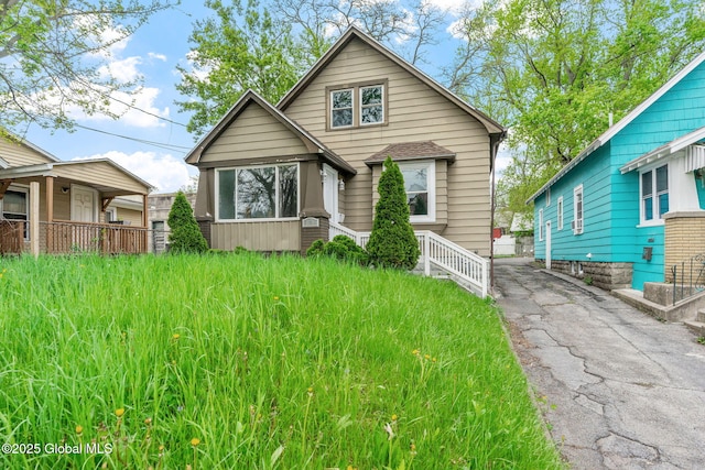 bungalow featuring asphalt driveway