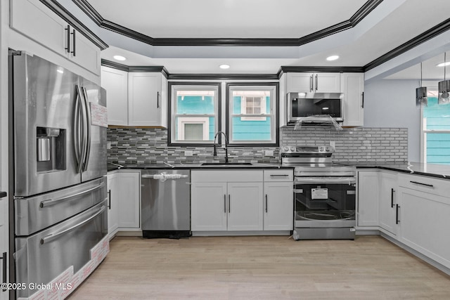 kitchen featuring appliances with stainless steel finishes, a sink, ornamental molding, dark countertops, and tasteful backsplash