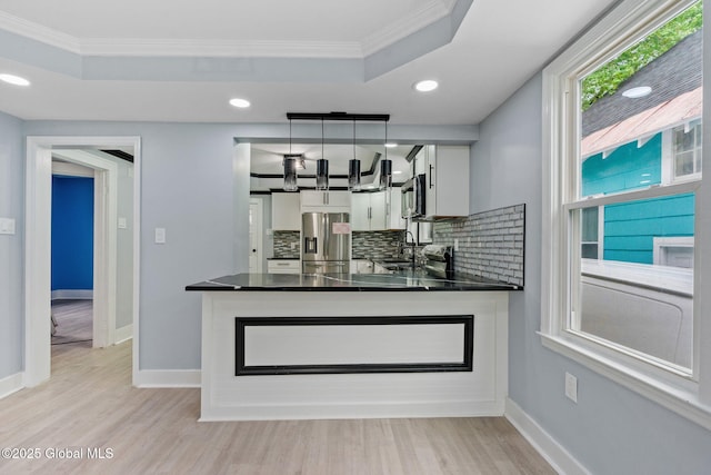 bar area featuring appliances with stainless steel finishes, ornamental molding, a raised ceiling, a sink, and decorative backsplash