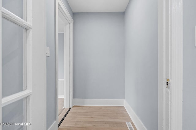 corridor with wood finished floors and baseboards