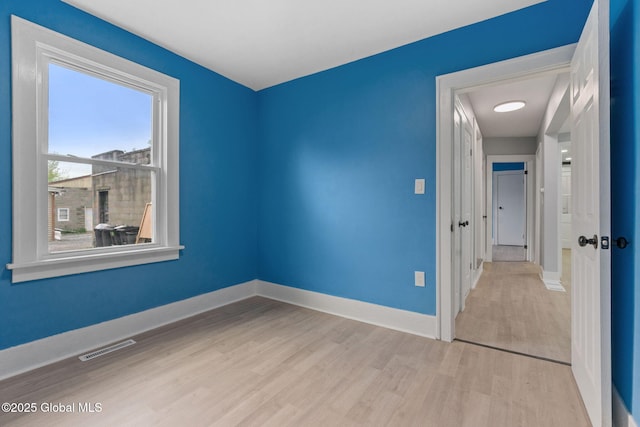 spare room featuring wood finished floors and baseboards