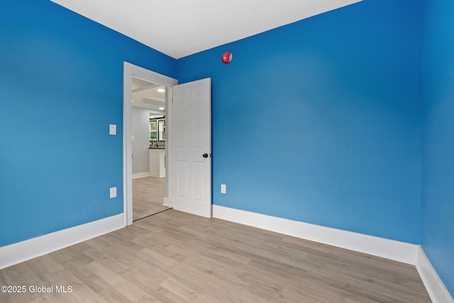 unfurnished room with wood finished floors and baseboards