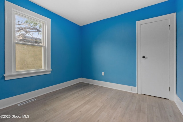 spare room with wood finished floors and baseboards