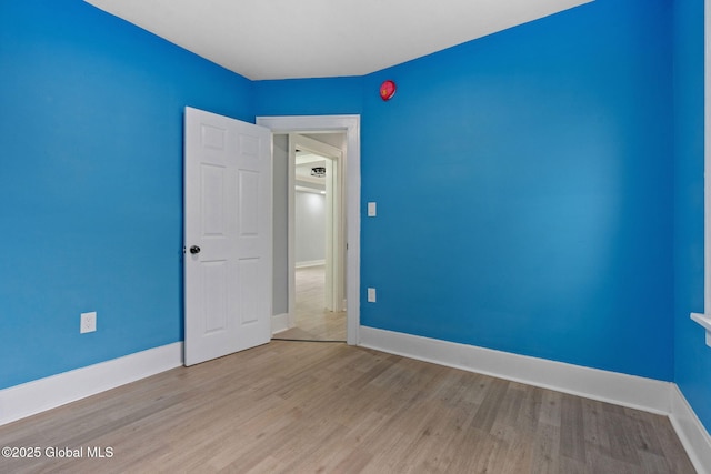 spare room featuring wood finished floors and baseboards