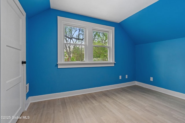 additional living space featuring vaulted ceiling, wood finished floors, and baseboards