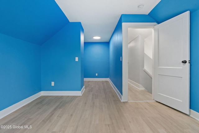 bonus room featuring wood finished floors, vaulted ceiling, and baseboards