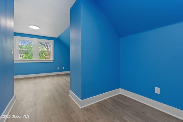 bonus room with lofted ceiling, wood finished floors, and baseboards