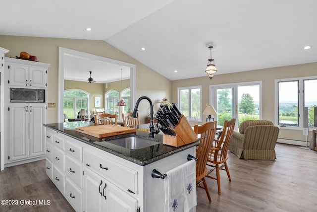6510 State Route 10, Seward, NY 13459 - kitchen with a sink, vaulted ceiling, plenty of natural light, a baseboard heating unit, and wood finished floors