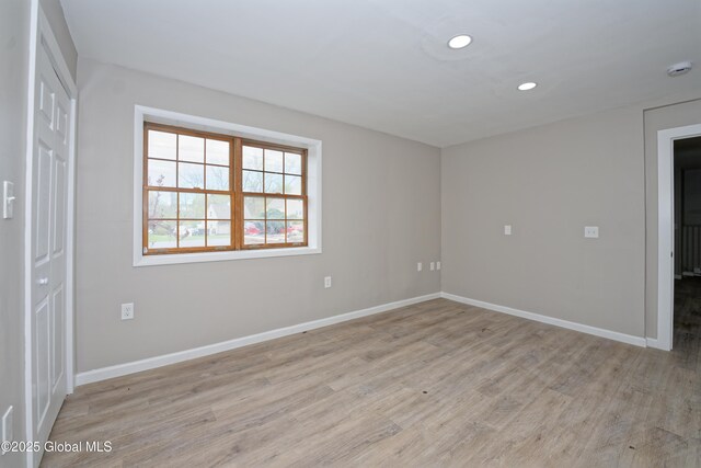unfurnished room featuring light wood-style floors, baseboards, recessed lighting, and a smoke detector