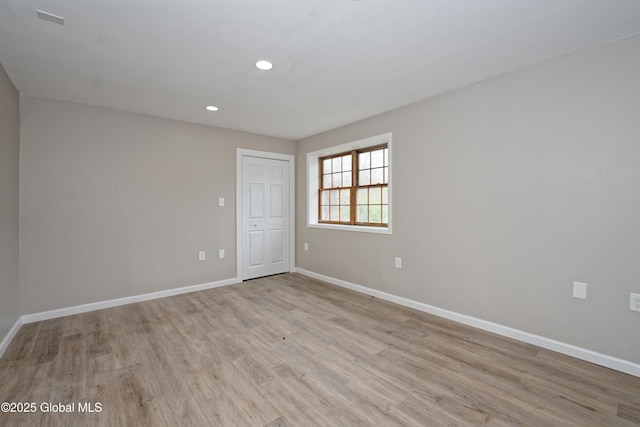 empty room with baseboards, light wood-style flooring, and recessed lighting