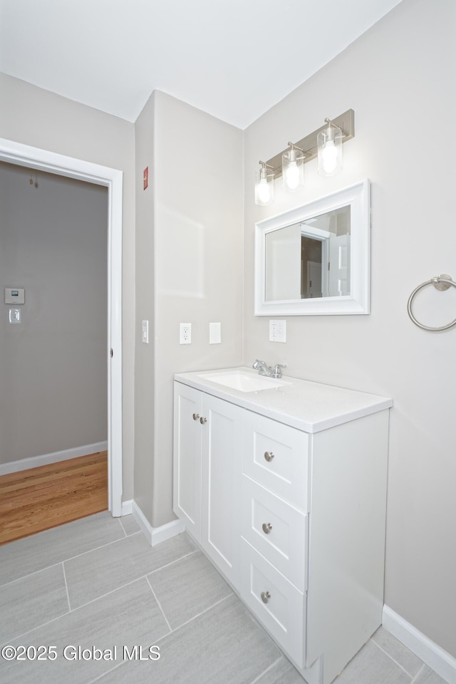bathroom with baseboards, vanity, and tile patterned flooring