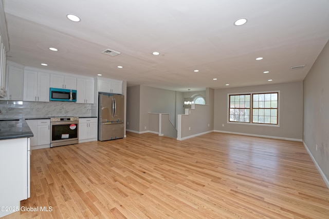kitchen featuring stainless steel appliances, dark countertops, recessed lighting, baseboards, and tasteful backsplash
