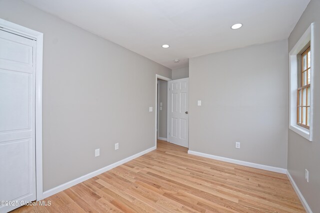 unfurnished room with light wood-type flooring, baseboards, and recessed lighting