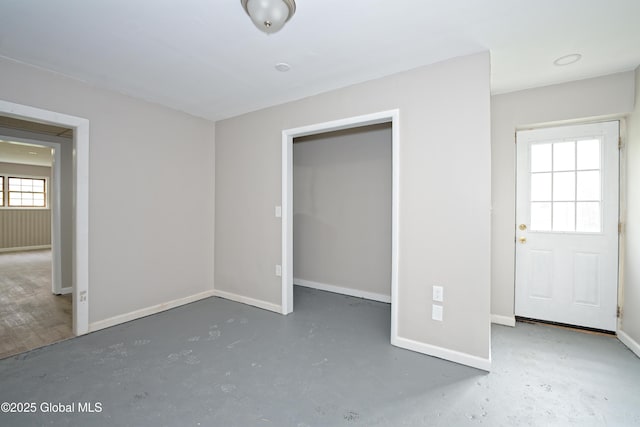 unfurnished bedroom featuring concrete floors and baseboards