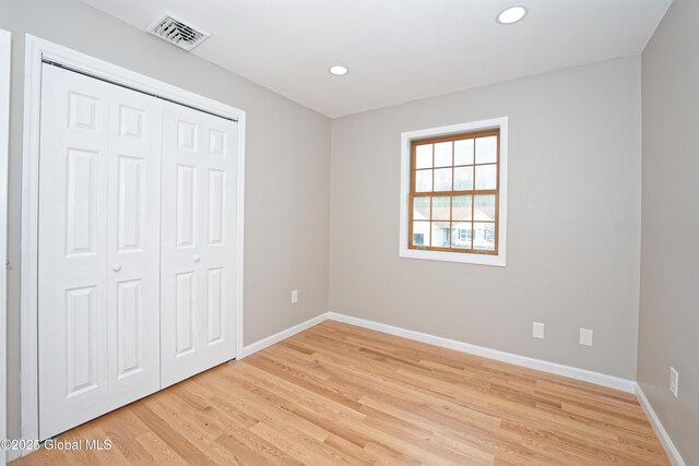 unfurnished bedroom with light wood-style floors, recessed lighting, and baseboards