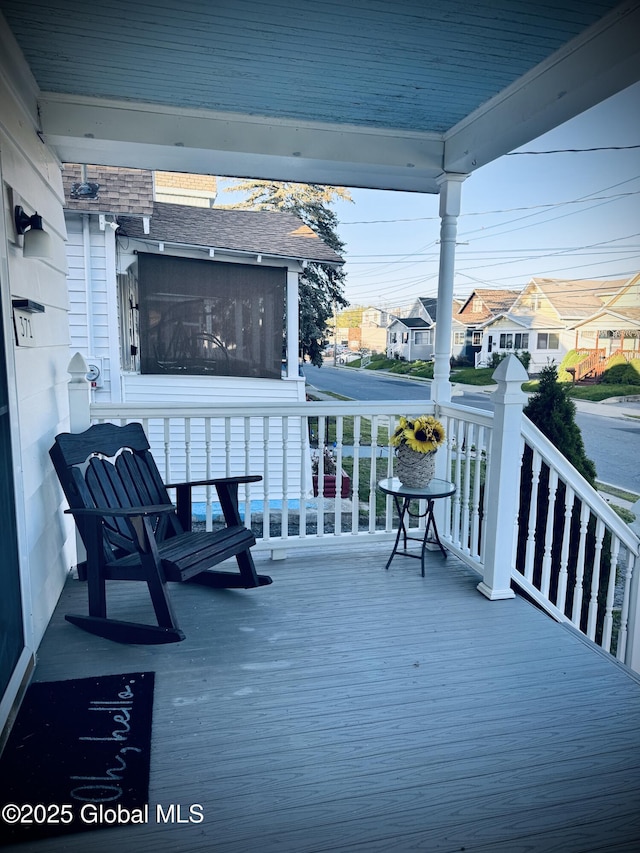 wooden terrace featuring a porch and a residential view