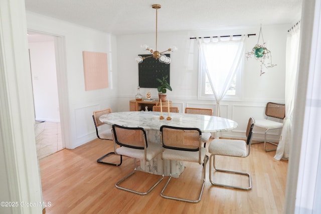 5 Moon Dr, Saratoga Springs, Inside, NY 12866 - dining space featuring wood finished floors, a chandelier, a decorative wall, and a wainscoted wall