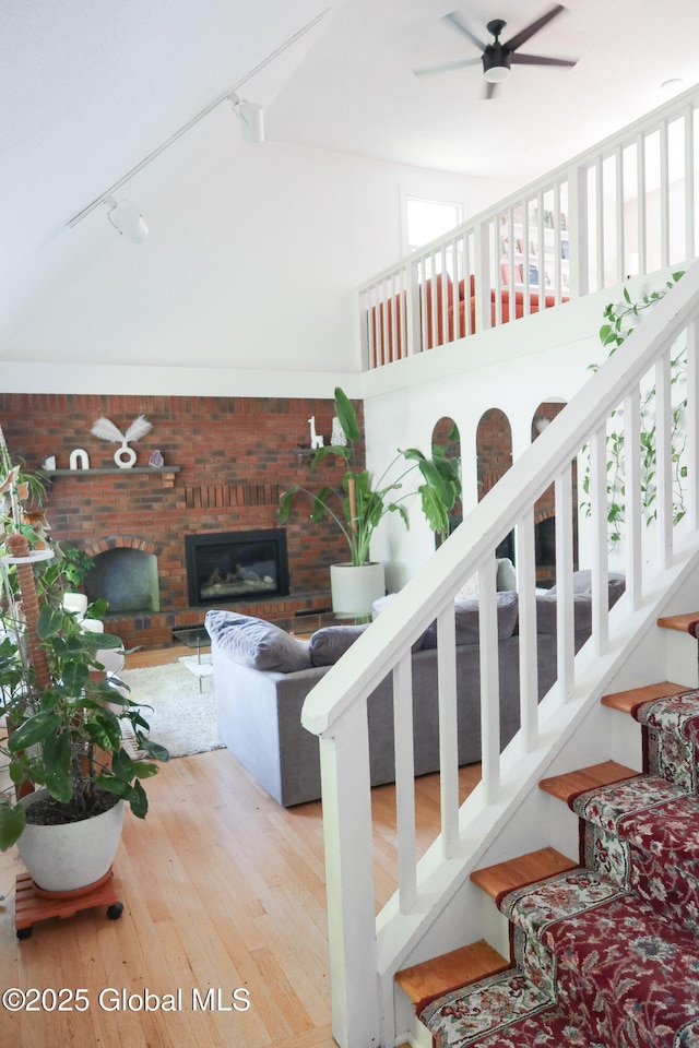 5 Moon Dr, Saratoga Springs, Inside, NY 12866 - staircase with a brick fireplace, wood-type flooring, a ceiling fan, a towering ceiling, and rail lighting