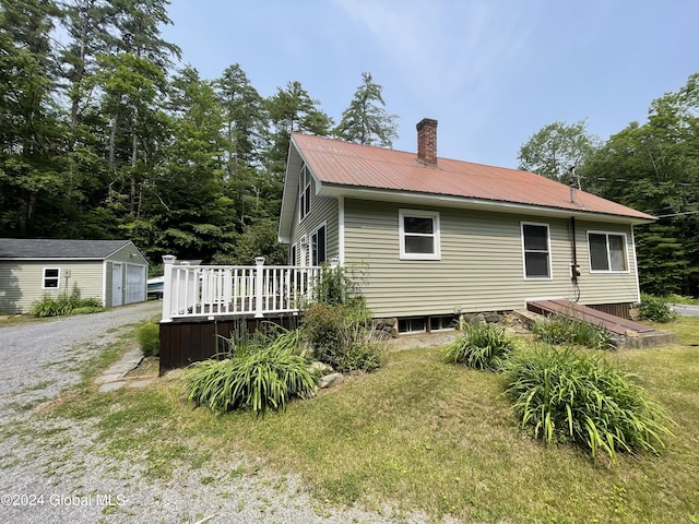 166 Finkle Rd, Bolton, NY 12814 - rear view of property with an outbuilding, a wooden deck, a chimney, metal roof, and a lawn
