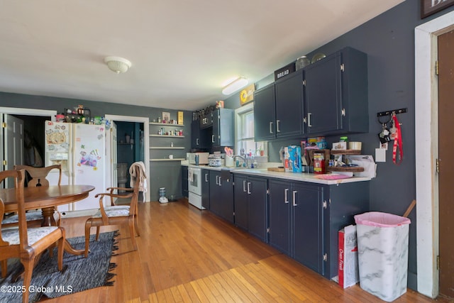 177 County Highway 155, Mayfield, NY 12025 - kitchen featuring white appliances, light wood-style flooring, light countertops, and blue cabinetry