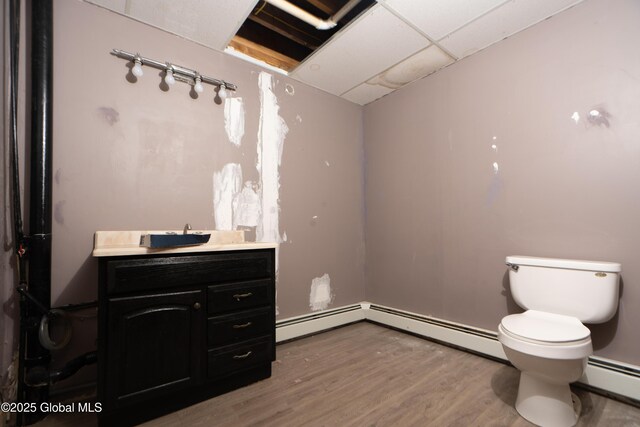 177 County Highway 155, Mayfield, NY 12025 - half bath featuring a baseboard radiator, toilet, wood finished floors, and vanity