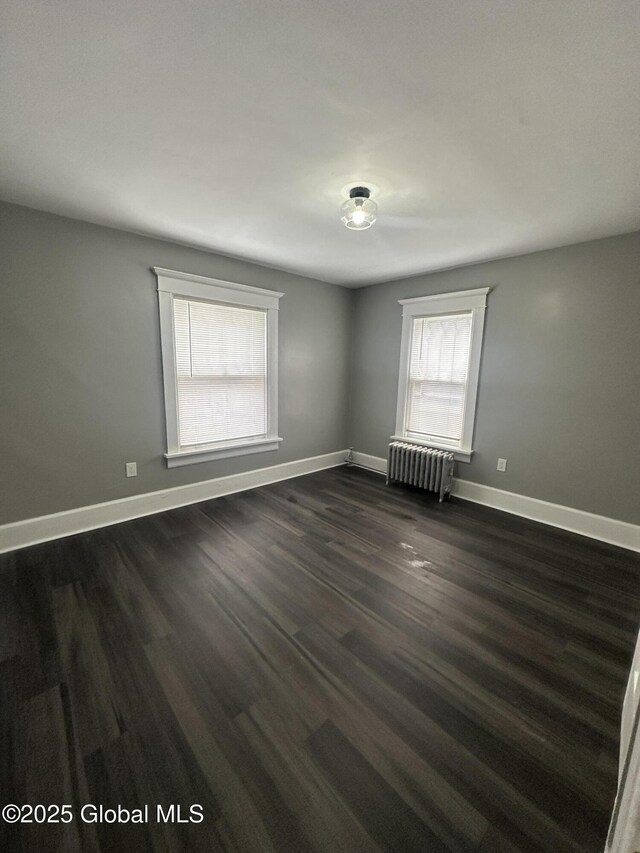 6 Alvey St, Schenectady, NY 12304 - spare room featuring radiator heating unit, healthy amount of natural light, baseboards, and dark wood-type flooring