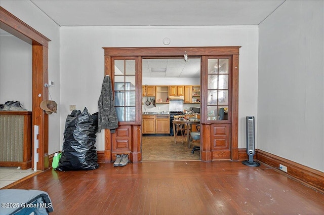 living room with hardwood / wood-style flooring, baseboards, and crown molding