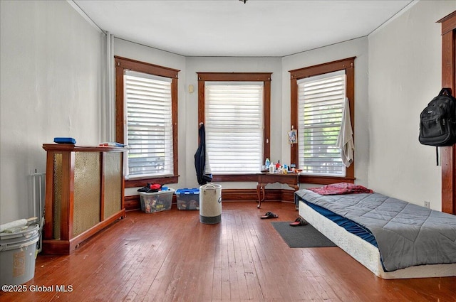 bedroom with hardwood / wood-style flooring and baseboards