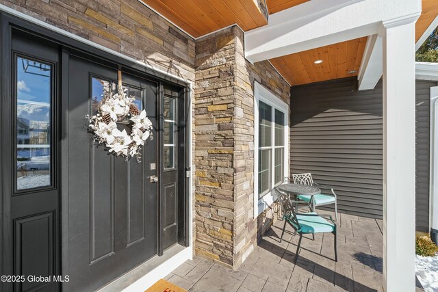 entrance to property with stone siding and covered porch