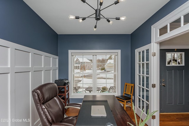 home office with a chandelier and wood finished floors