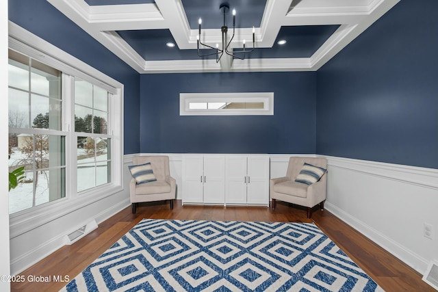 living area featuring coffered ceiling, a chandelier, dark wood finished floors, crown molding, and beam ceiling