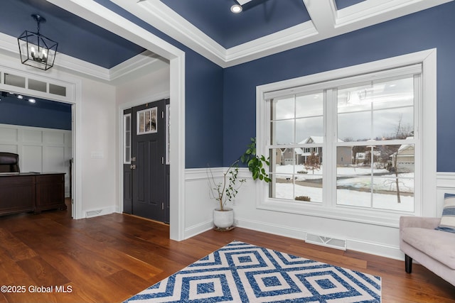 sitting room featuring wood finished floors, a decorative wall, wainscoting, and a chandelier