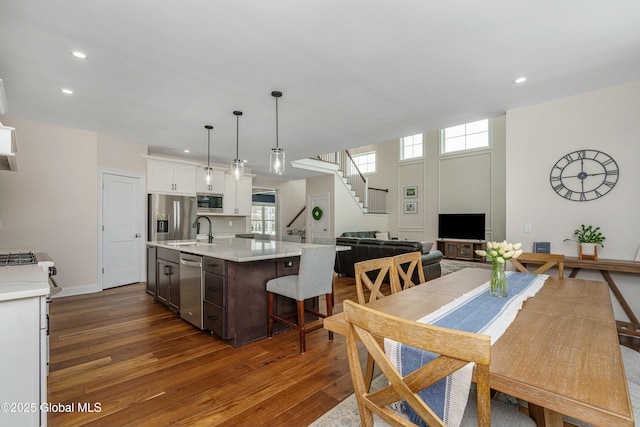 dining area with dark wood-type flooring, stairway, recessed lighting, and baseboards