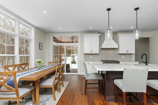 kitchen with premium range hood, decorative backsplash, recessed lighting, healthy amount of natural light, and white cabinets