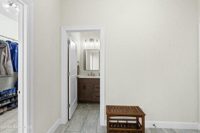 hallway with a sink and baseboards