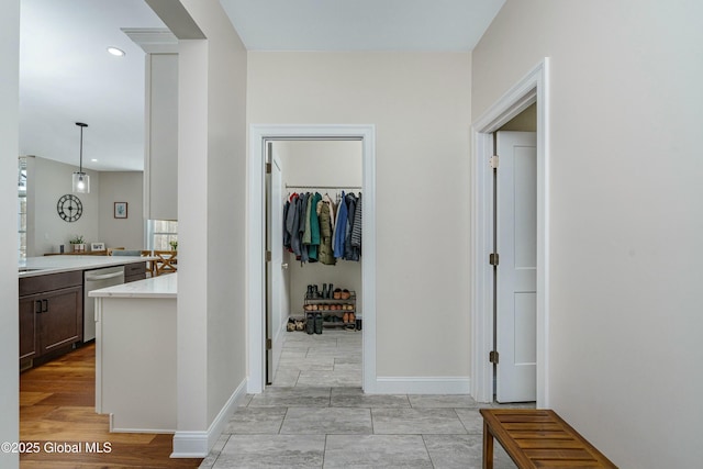 corridor with healthy amount of natural light, baseboards, and recessed lighting