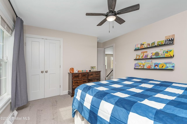 bedroom featuring light carpet, a closet, and ceiling fan