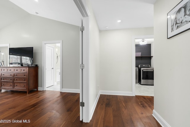 hallway featuring hardwood / wood-style floors, baseboards, and lofted ceiling