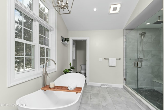 bathroom with a stall shower, a chandelier, baseboards, a freestanding tub, and lofted ceiling