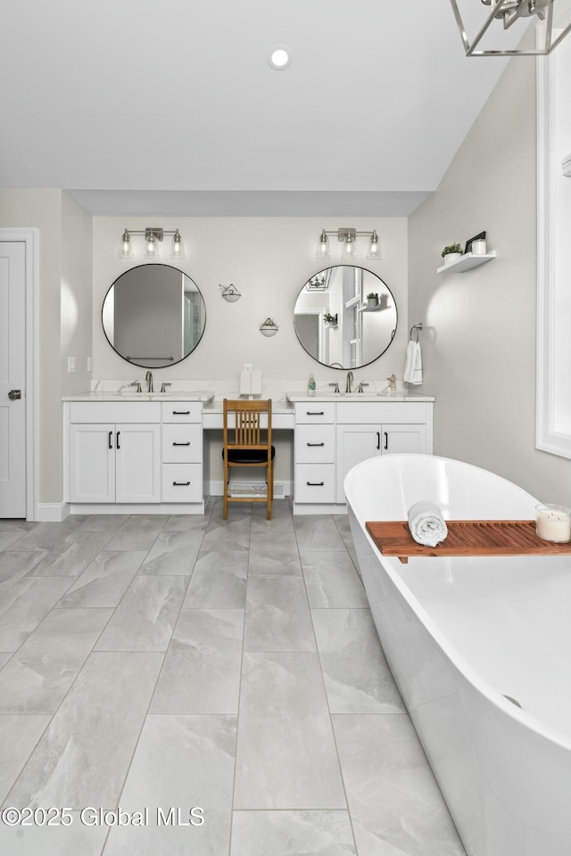 full bathroom with a freestanding bath, vanity, marble finish flooring, recessed lighting, and baseboards