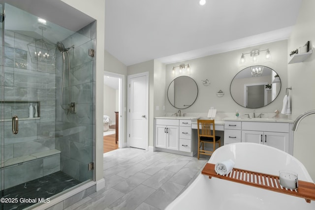 full bath with a stall shower, a freestanding bath, vanity, lofted ceiling, and baseboards