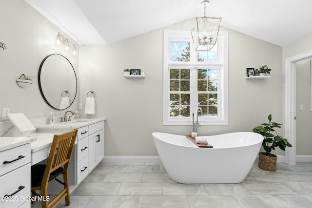 full bathroom featuring marble finish floors, lofted ceiling, vanity, a chandelier, and a soaking tub