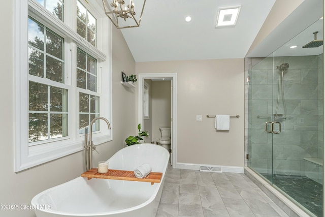 bathroom featuring a shower stall, baseboards, a chandelier, a freestanding tub, and lofted ceiling