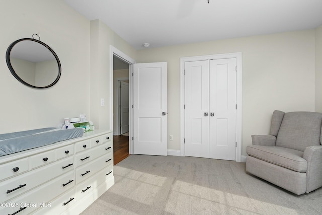 living area featuring light carpet and baseboards