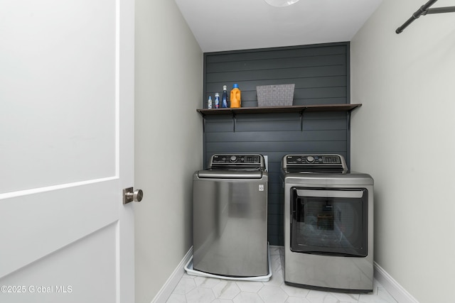 clothes washing area with washing machine and dryer and baseboards