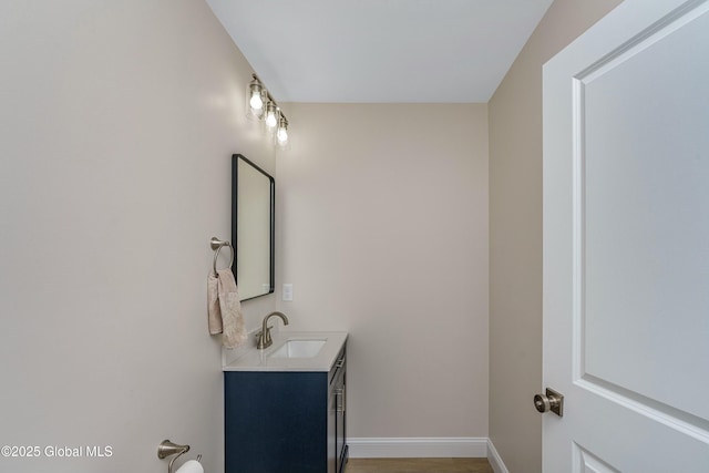 bathroom featuring vanity, baseboards, and wood finished floors