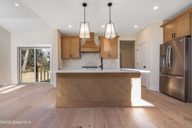 kitchen featuring stainless steel fridge with ice dispenser, custom exhaust hood, light countertops, baseboards, and backsplash