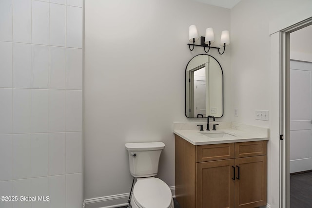bathroom with vanity, toilet, and baseboards